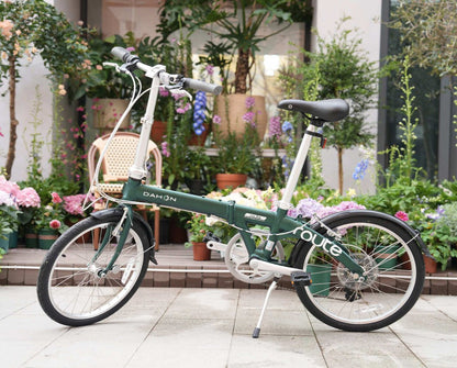 Dark green Dahon Route foldable bicycle with aluminum frame, black fenders, and multi-gear system, displayed outdoors.